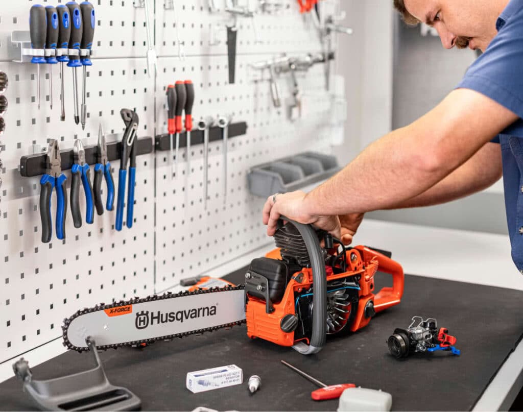 Hombre manipula motosierra Husqvarna en un taller